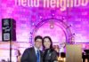 Neighborhood Nosh 2025 by Hello Neighbor A man in a suit and a woman in a pink and purple dress stand together.