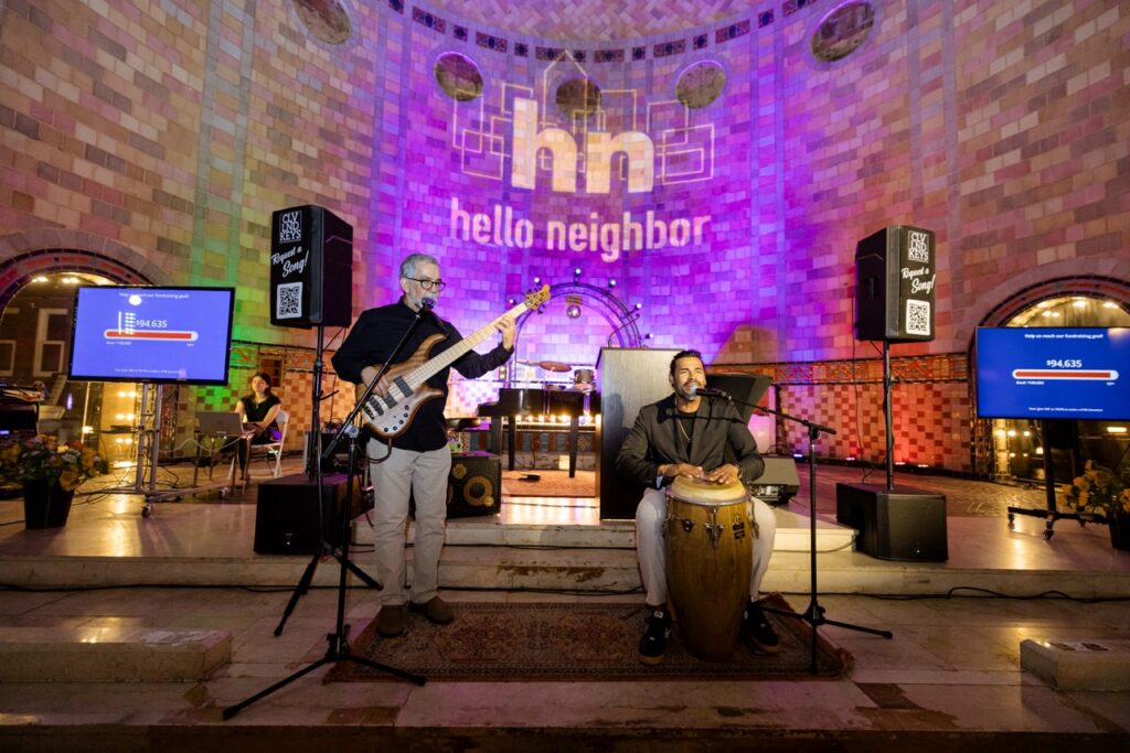 A man plays bass while another man plays a bongo drum.