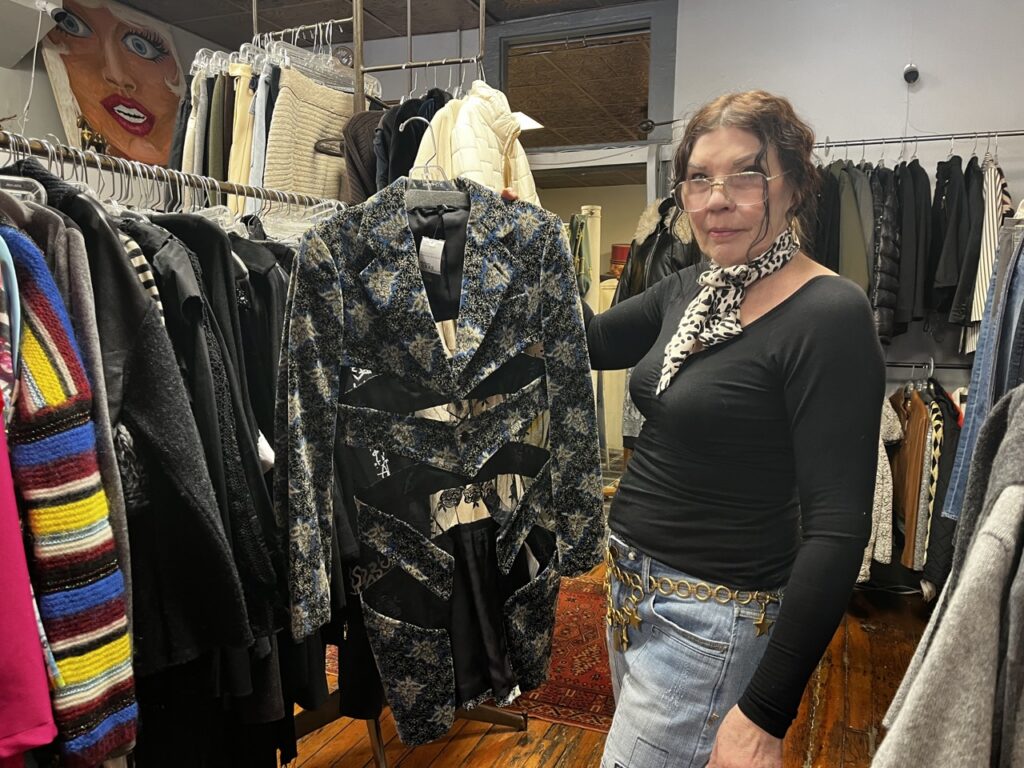 Jacqueline Stone holds up a designer jacket.