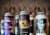 Pittsburgh’s March Beer Bracket: 16 Brews Go Head-to-Head Tall beer cans stand on a tray, reflected in the table below them.