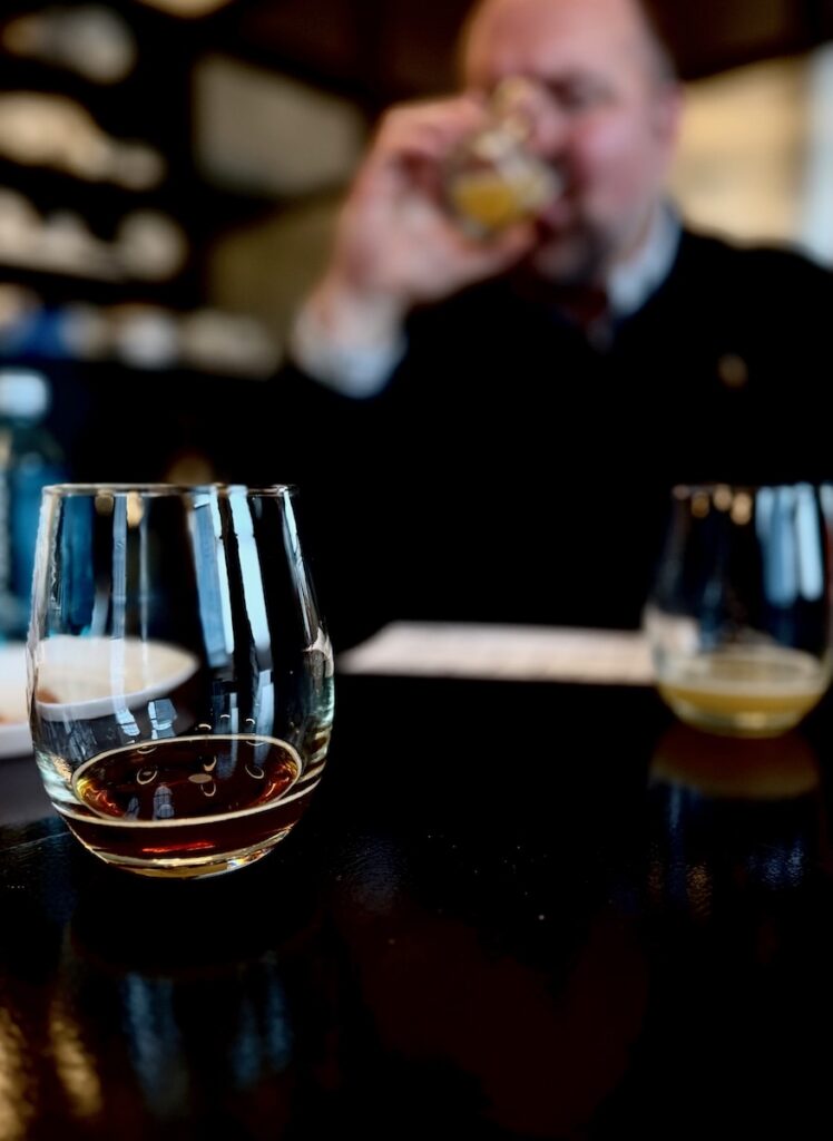 A man drinks a glass of beer.