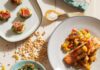 Pineapple Season Starts with These Recipes Baked salmon topped with pineapple mango salsa sits on a white dishes.