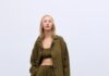 6 Must-Have Items From 2026 Spring Fashion Trends A woman in a long green trench coat with pants and top to match.
