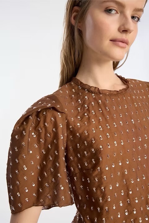 A woman in a brown pattern shirt.