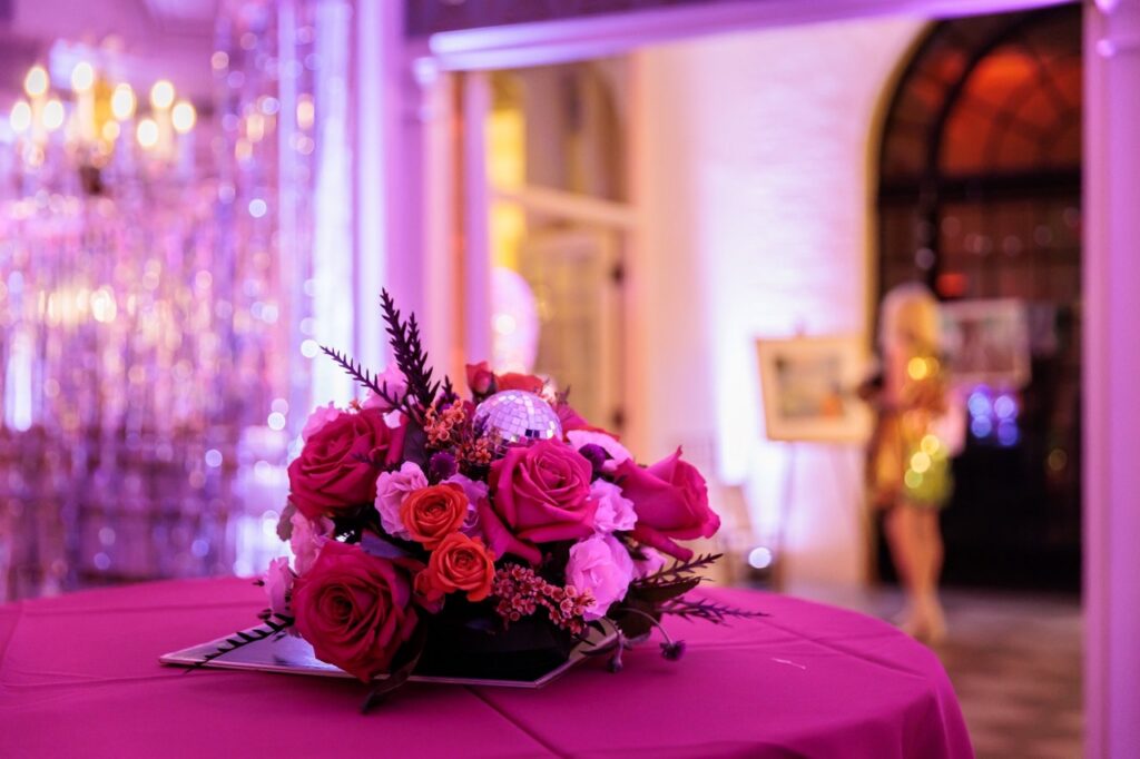 A bouquet of pink and red flowers on a pink table.