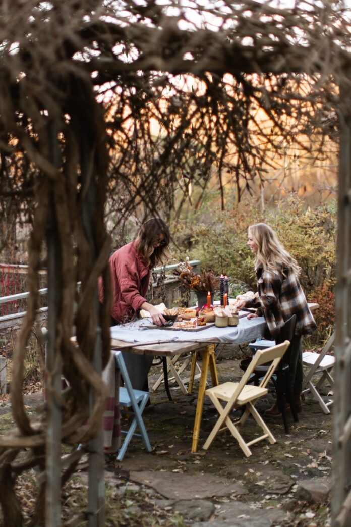 An outdoor autumn feast featuring gourmet grilled cheese sandwiches, charcuterie, and popcorn served on a marble slab with sky-blue linens on a rustic patio near Pittsburgh.