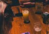 Trivia Nights in Pittsburgh: The Analog Trend Making a Comeback A woman writes on a trivia night answer pad at a table.