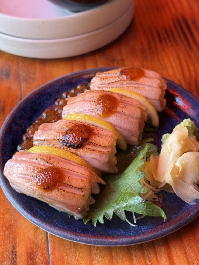 Four pieces of sushi sit on a blue plate.