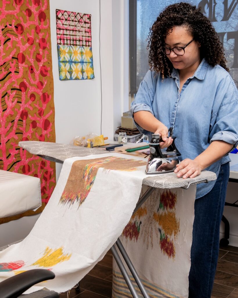 Addoley Dzegede irons one of her textile art pieces.