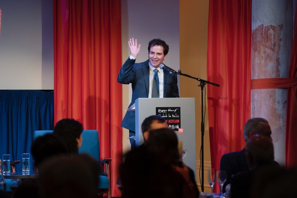 Andres Franco stands at a stand to give a speech at City of Asylum.