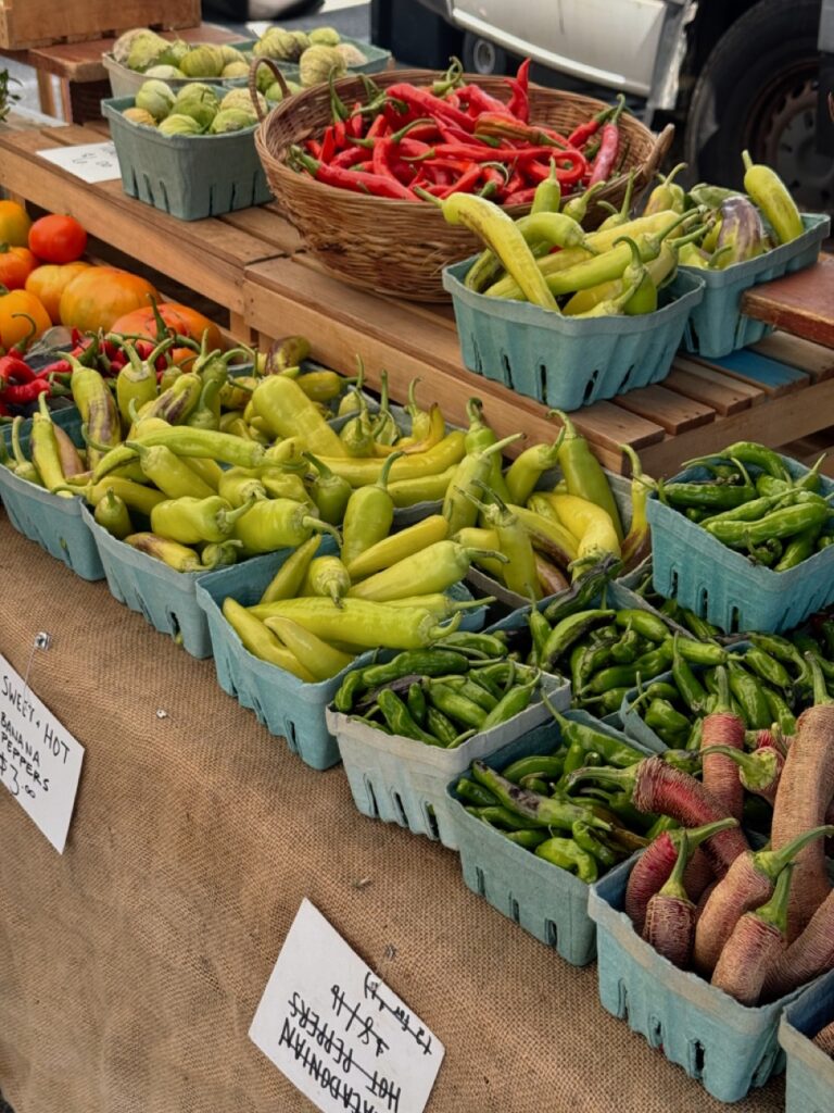 Baskets full of peppers at a farmer's market.