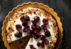 Black Forest Cake A Black Forest Cake in a pan with white frosting and brandied cherries on top.