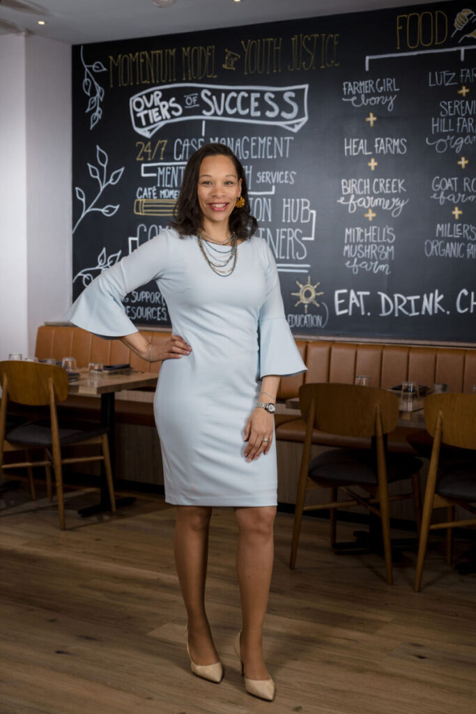 A woman in a long grey dress in a restaurant.