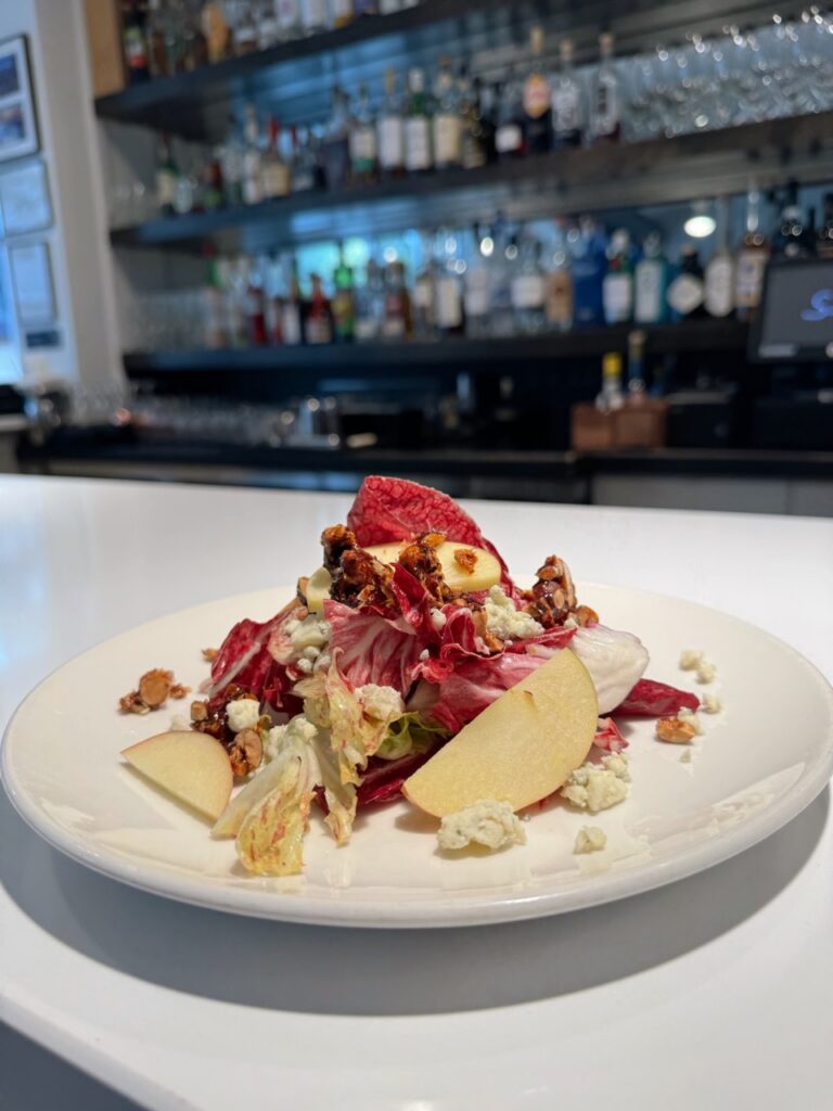 A white plate with a raddicio salad on top in purple color.