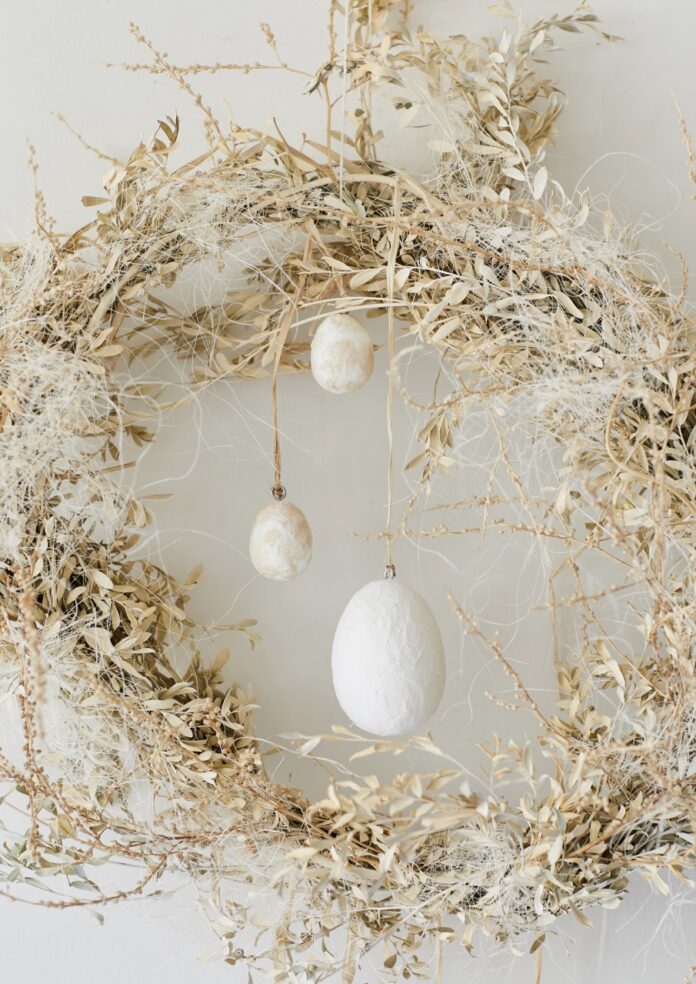 Three eggs hang from a DIY nest wreath.
