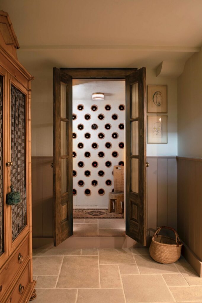 A peak through a door to a white wall with black dots.