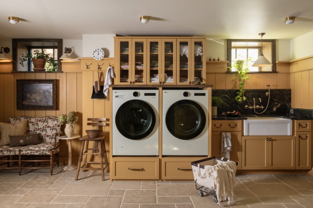A washer and dryer sit side by side surrounded by wood cabinetry.