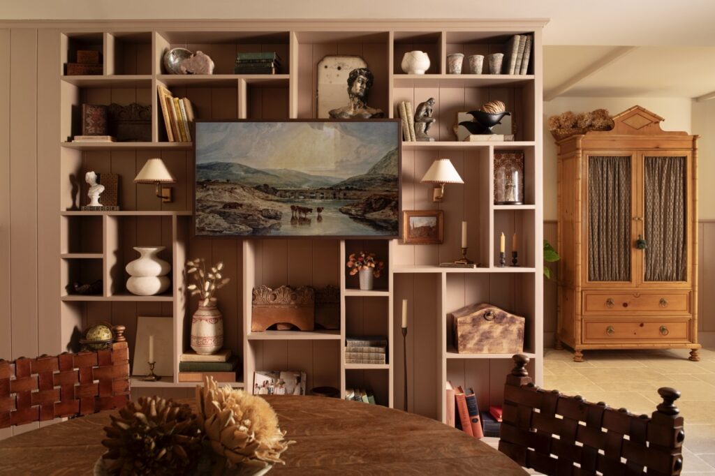 A TV hangs on a large display of shelves.