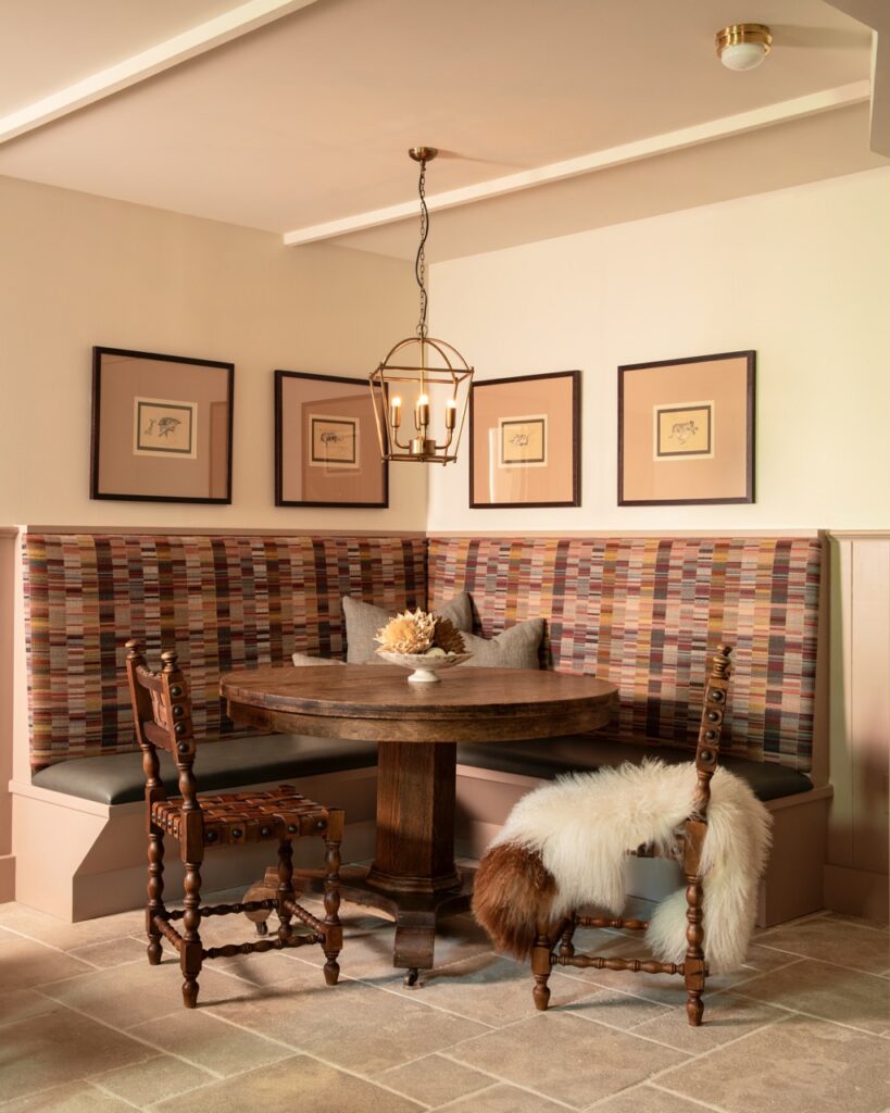 A corner booth and table in the nook of a dining room.