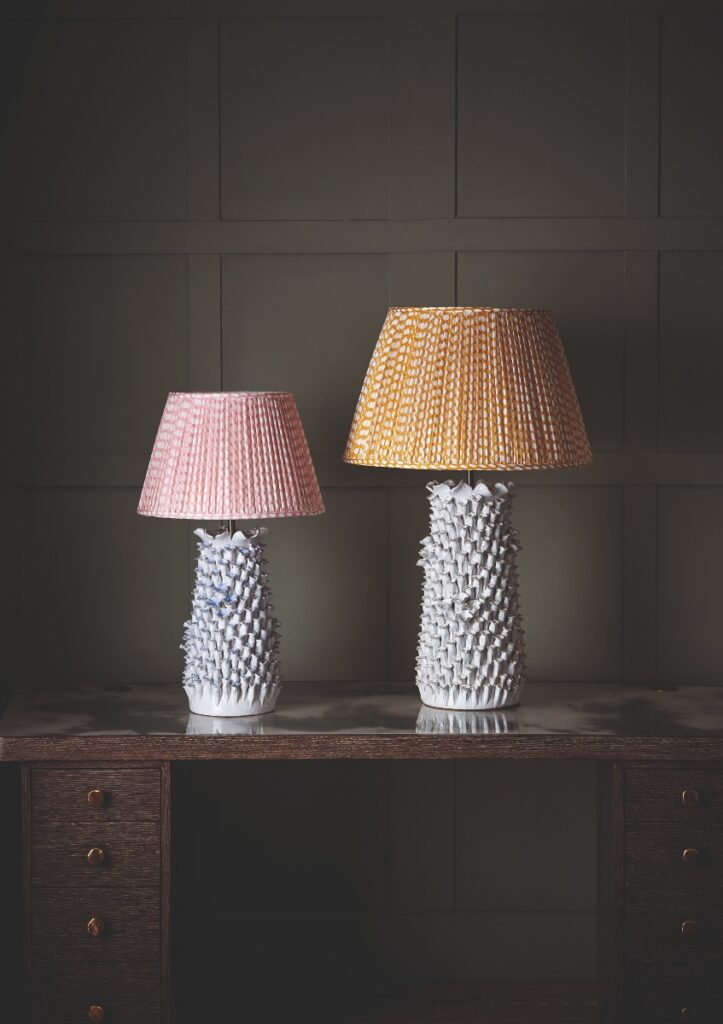 Two Julian Chichester ceramic Fairy lamps from Antiquarian Shop, featuring intricate handmade floral textures and colorful pleated shades in pink and yellow patterns.