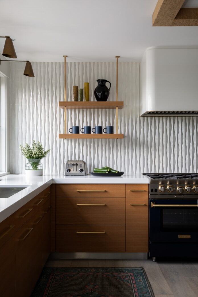 A "White Hot Reno" kitchen in a Fox Chapel farmhouse featuring hand-distressed white oak beams, a BlueStar range, and a glossy Walker Zanger chevron tile backsplash.