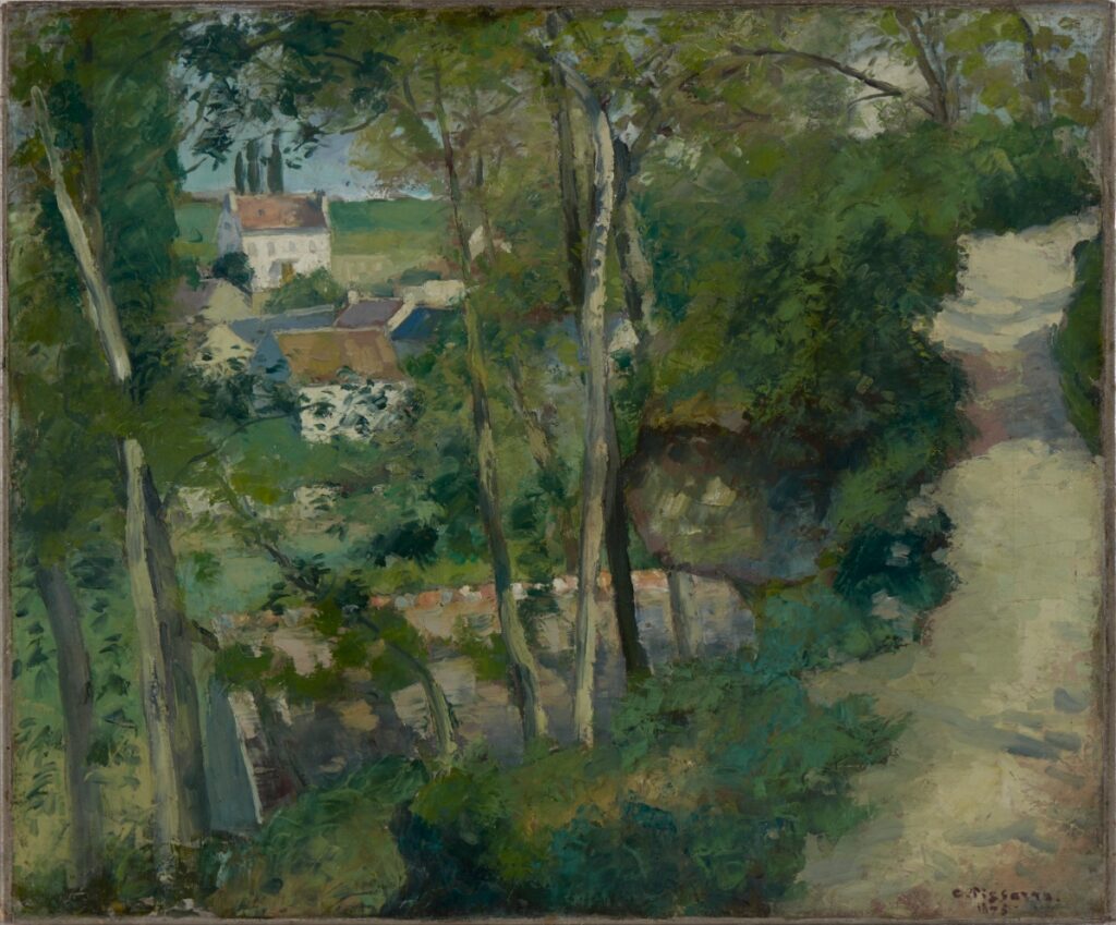 An Impressionist landscape painting by Camille Pissarro depicting a sun-dappled dirt path winding through lush green trees toward a cluster of white village houses in the distance.