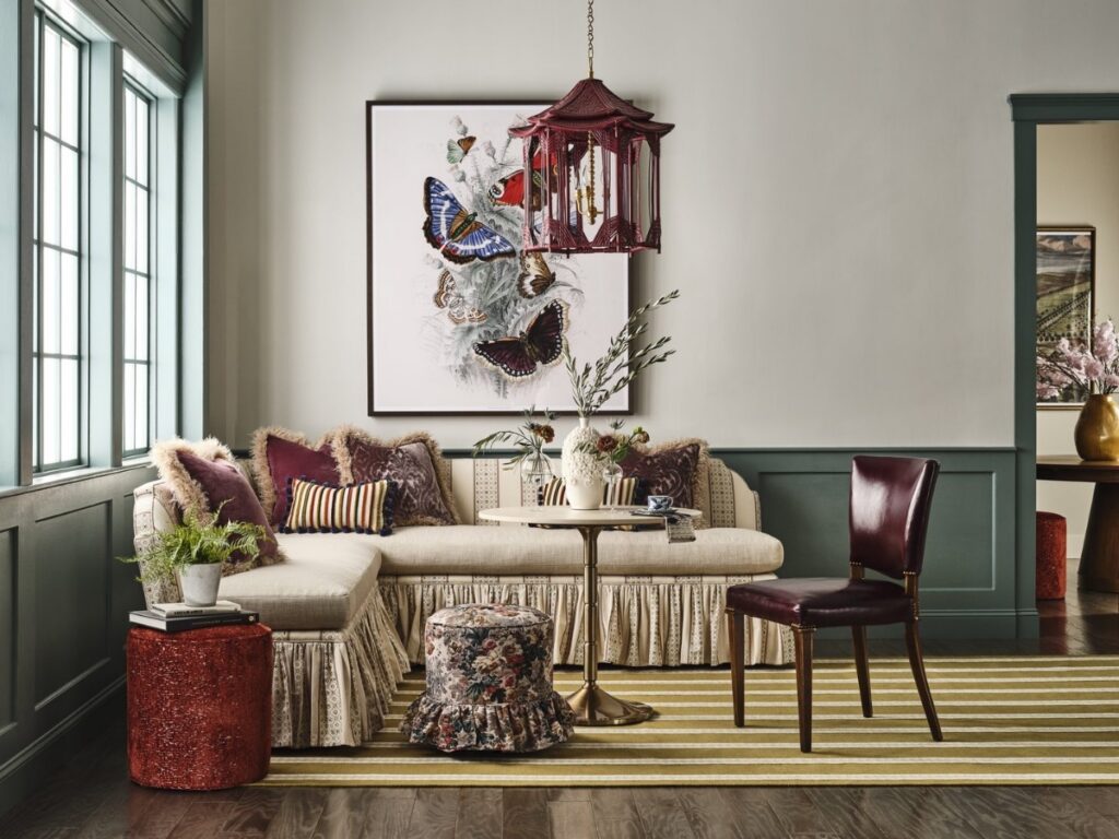 A whimsical English country-style living room featuring the Taylor King Collette banquet, Beauchamp chair, and Taylor Made sectional with a layered mix of floral patterns, stripes, and velvet textures.