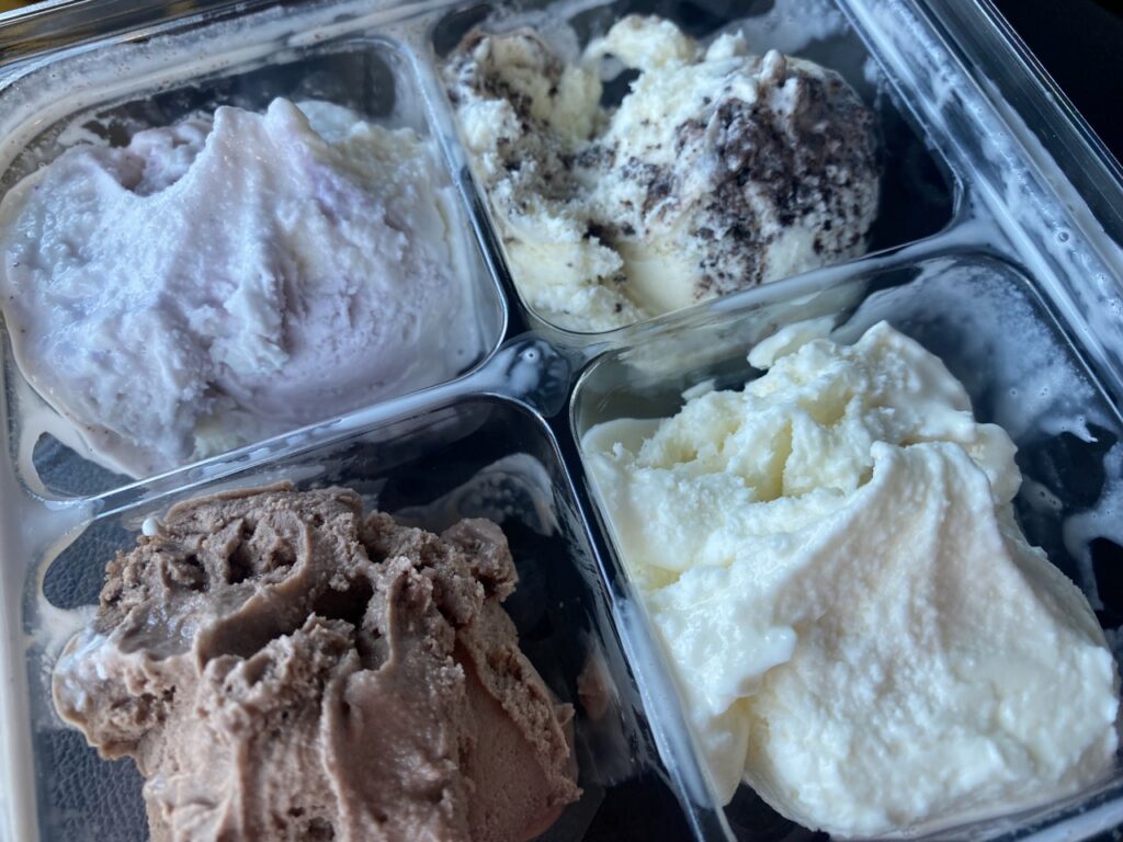 Four different flavors of ice cream in square containers.
