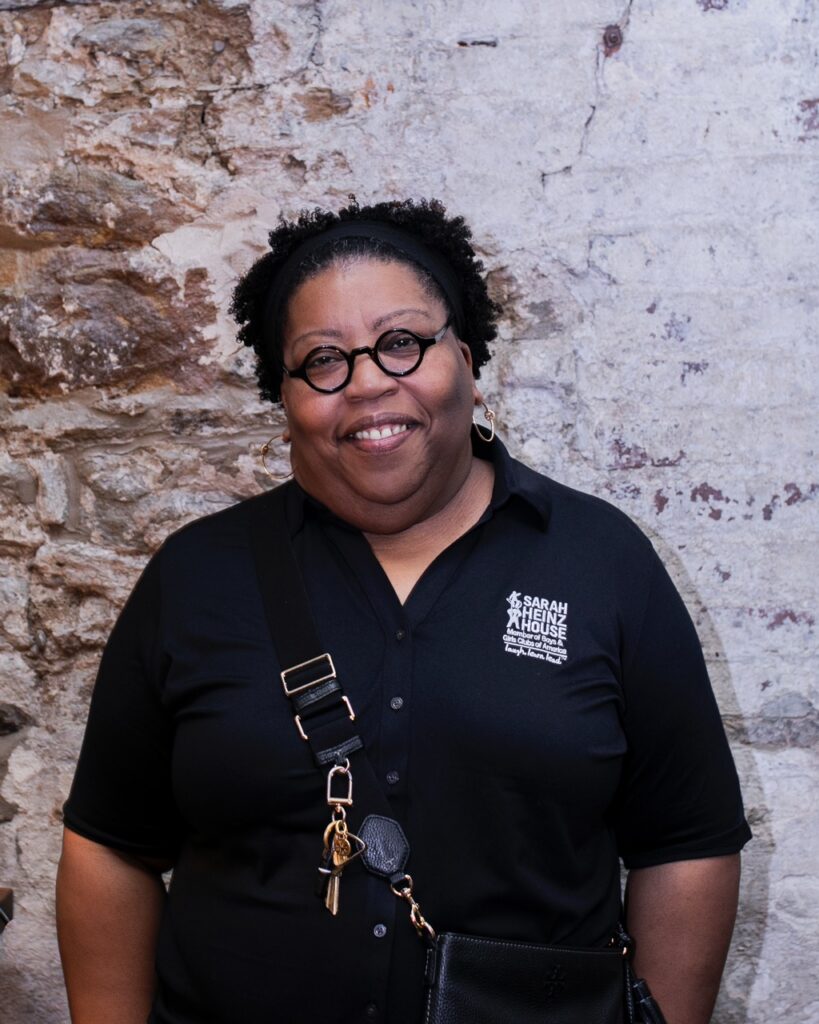 A woman in a black shirt with a purse across her body.
