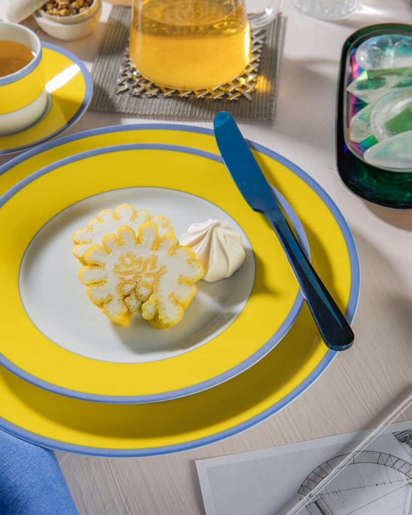 A stack of two yellow plates with a yellow Buddha hand chopped up on top of it.