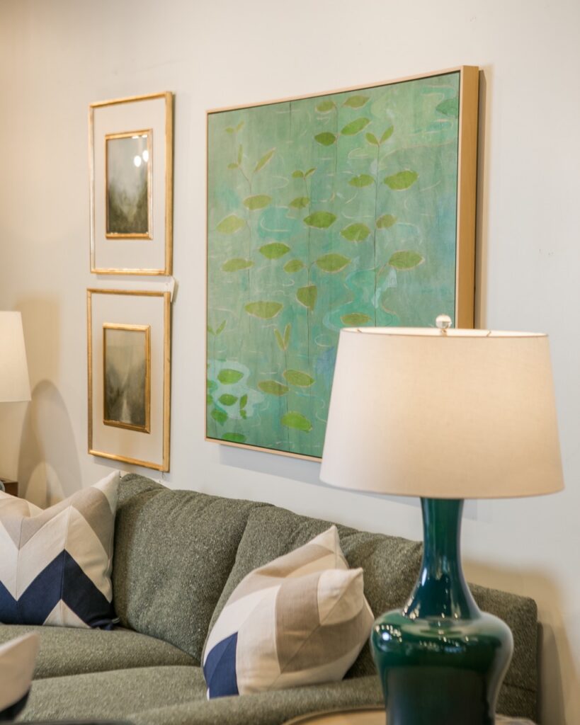 A blue painting beside two pictures on a white wall.