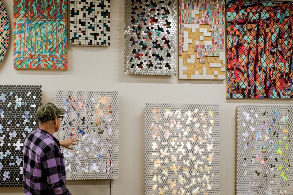 A variety of canvases with shimmering materials on them that Jeff Schwarz points out.