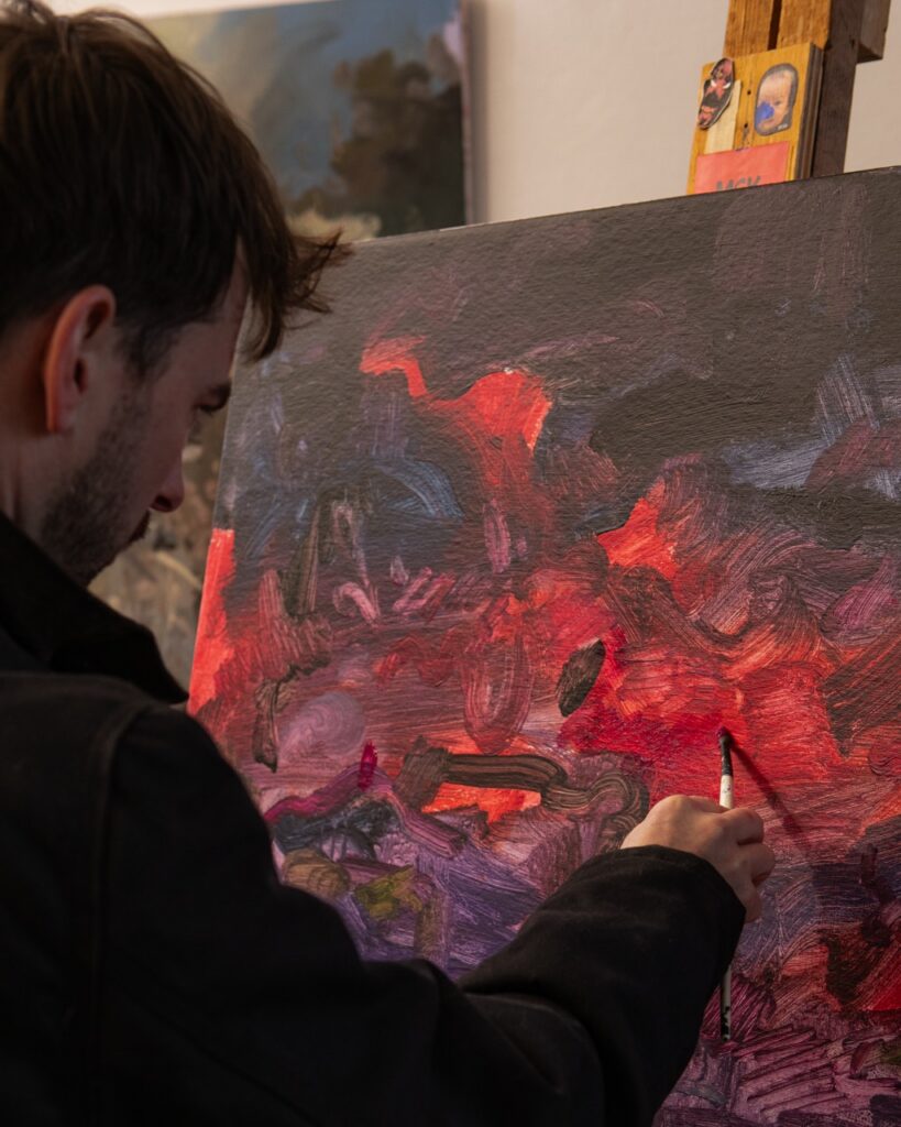 An artist paints colors onto an abstract canvas.