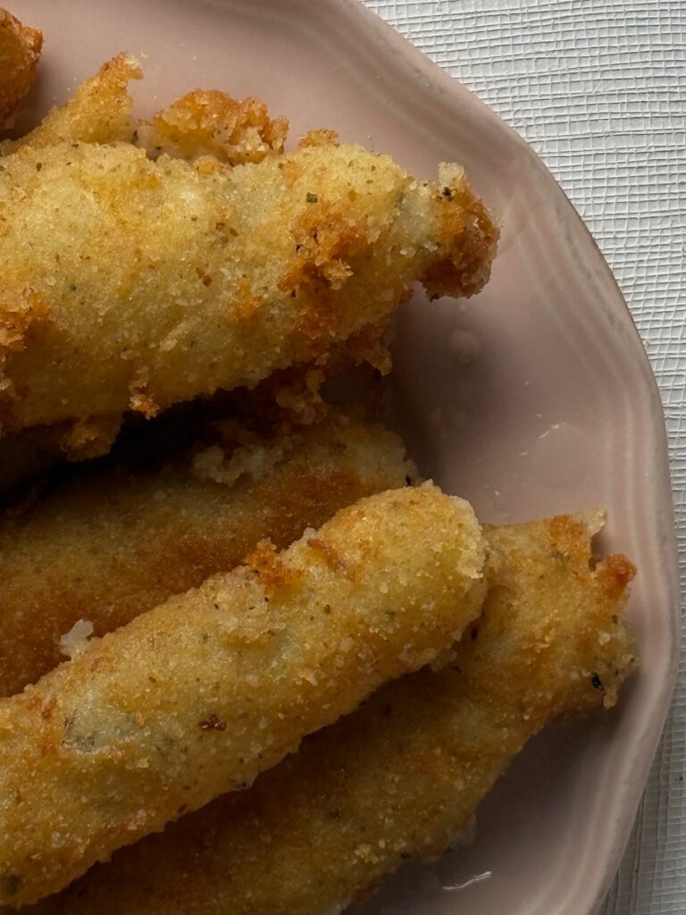 A stack of fried potato sticks on a pink plate.
