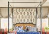 Designer Peter Dunham Transforms a Young Couple’s Home in Brentwood A blue couch sits at the end of a large four poster bed,