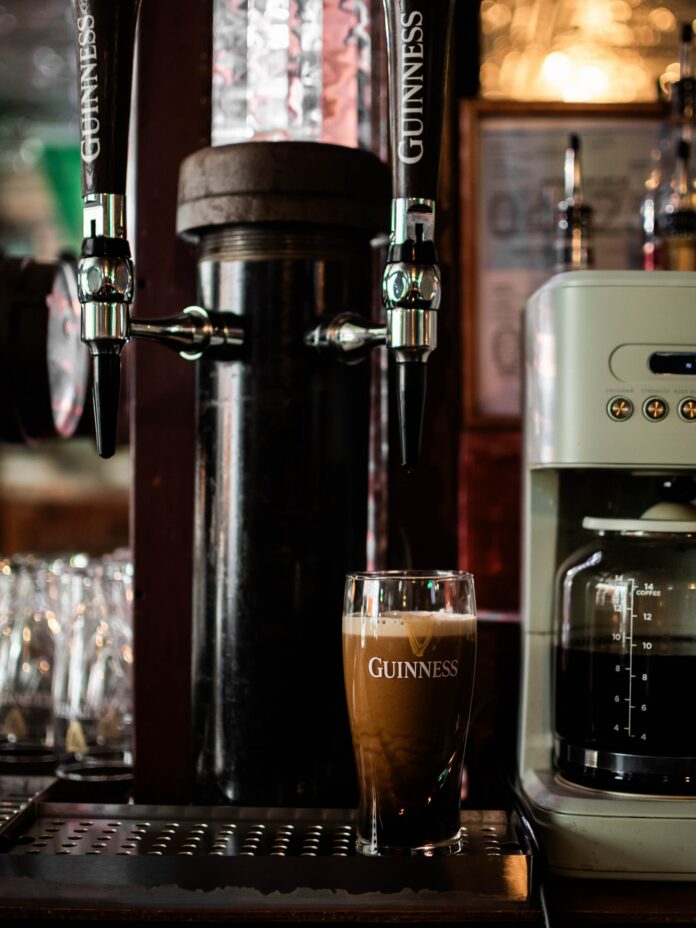 A glass of Guinness sits below a nitro tap at a Pittsburgh Irish pub.