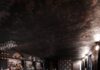 6 Pittsburgh Speakeasies Worth Finding The inside of a Pittsburgh speakeasy with a lowkey bar and booth seating along the wall.