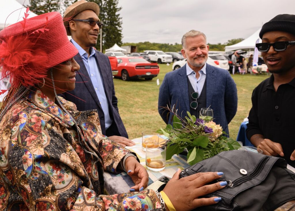Four people talk around an outdoor table.