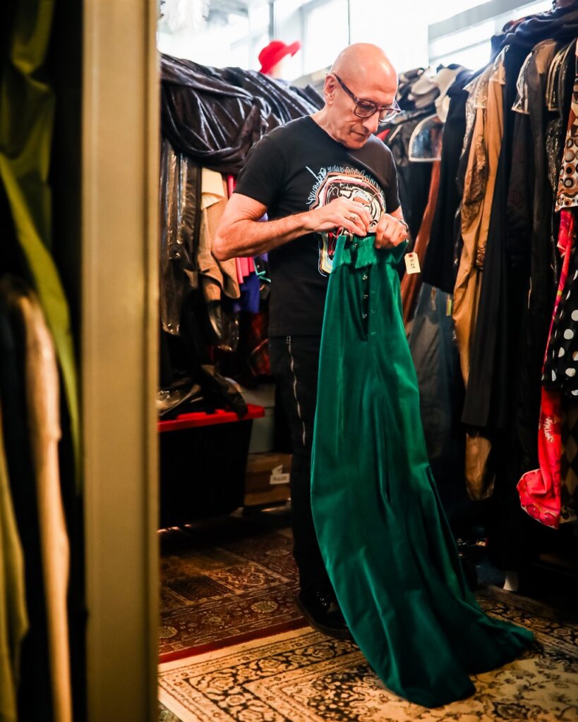Richard Parsakian folds a long green velvet dress.