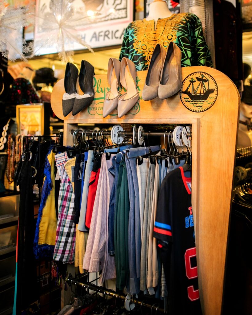 A rack of vintage clothing with shoes hanging above it.