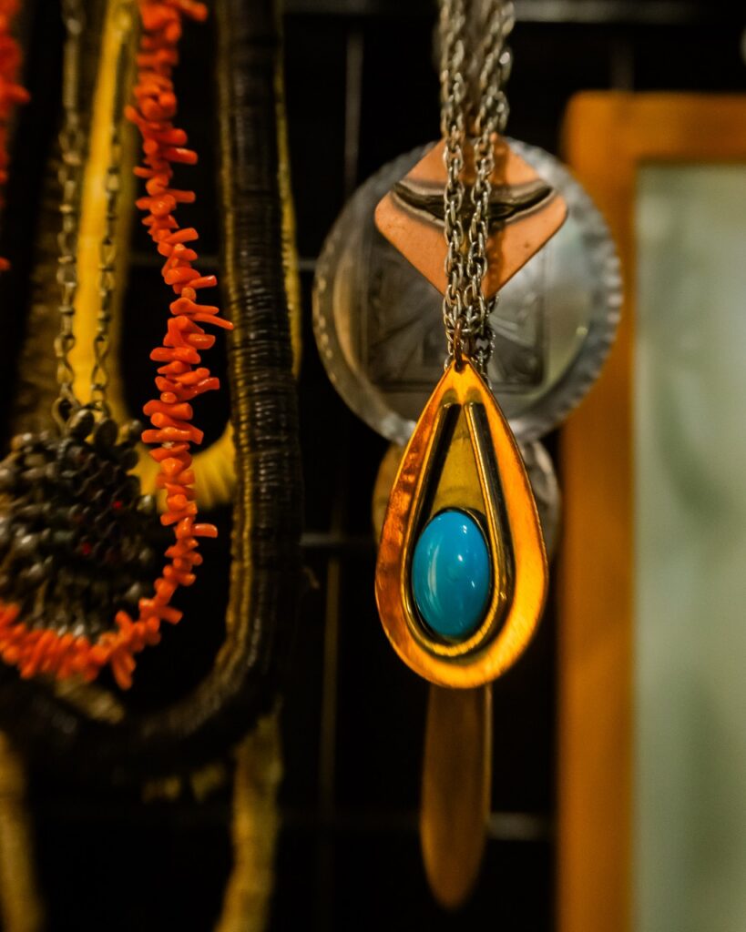 Vintage jewelry hangs from a stand.