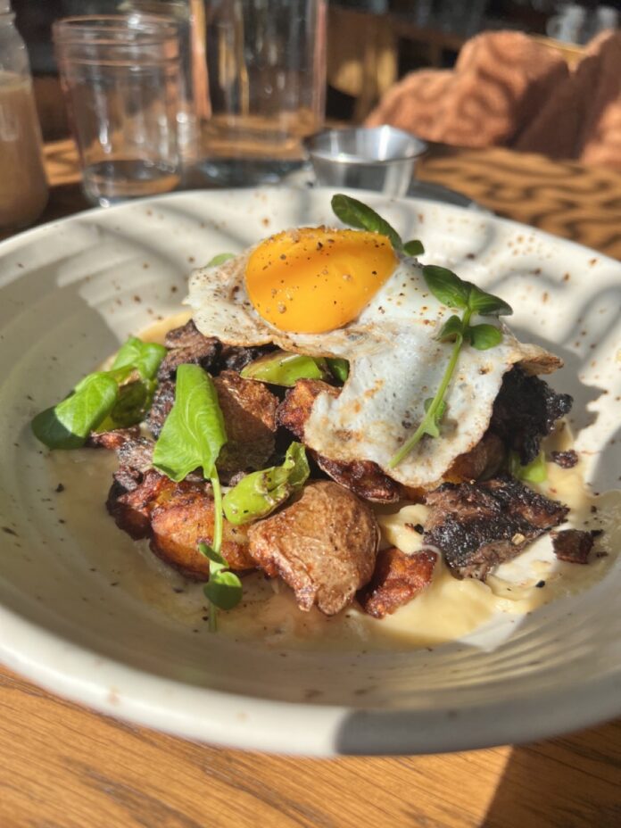 A plate with a breakfast scramble and egg on top.