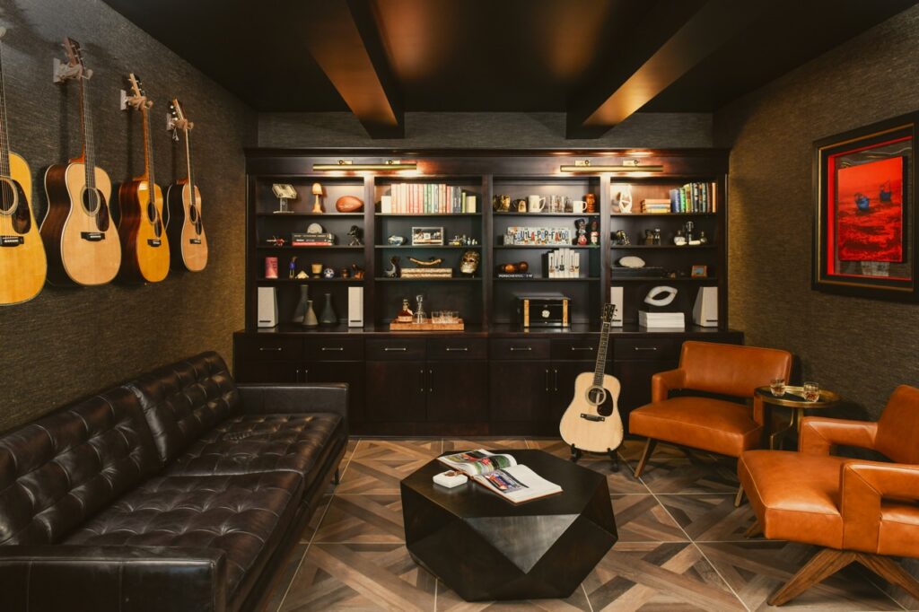 A large music room area with guitars on the walls plus leather chairs and couches.