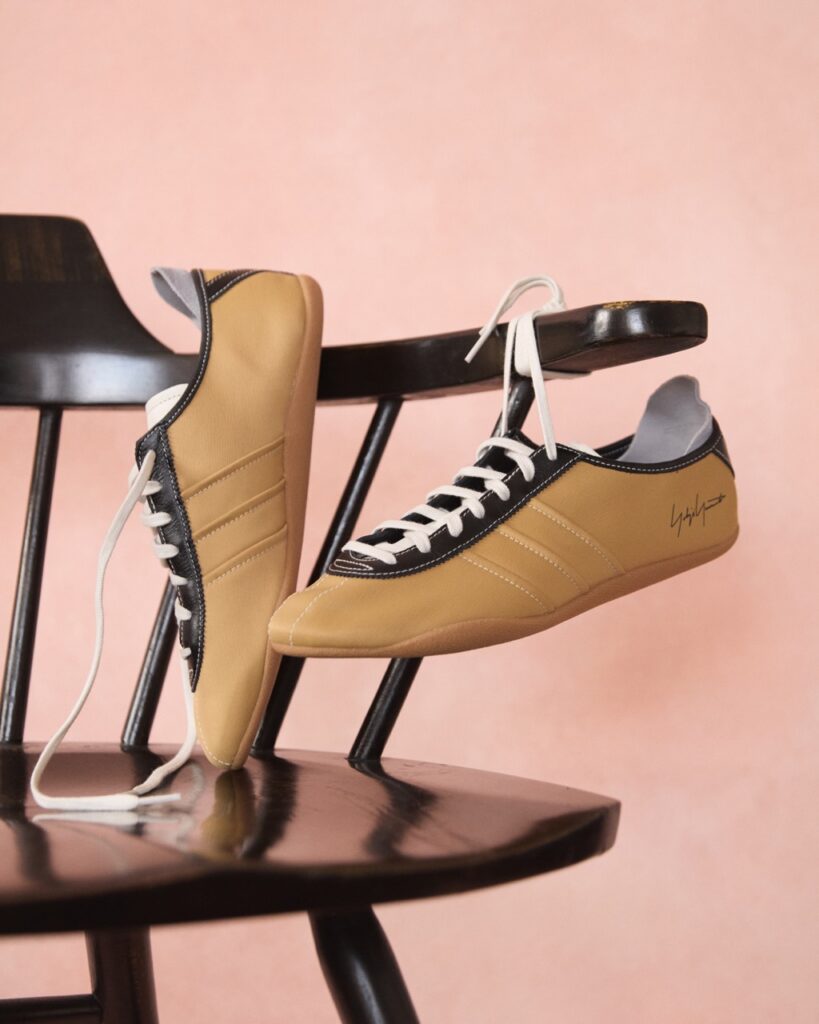 A pair of vintage brown tennis shoes hang off a brown chair.