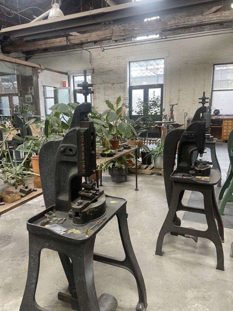 Various metalmaking stations with plants in the background.