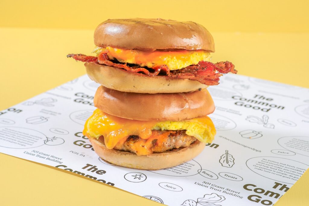 Two bagel breakfast sandwiches stacked on top of each other.