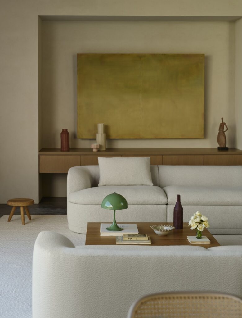 Modern living room featuring the DWR Atlason Composed Modular Sofa in cream melange, styled with a green Verner Panton Flowerpot lamp and minimalist Icelandic design elements.