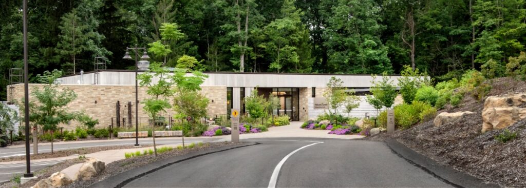 A fossilized dinosaur footprint embedded in a natural rock surface at the Pittsburgh Botanic Garden.