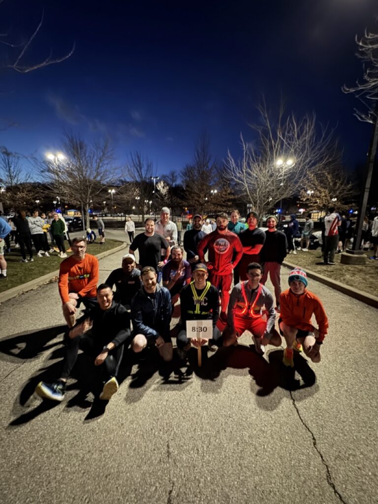 A group of runners gather together at night.