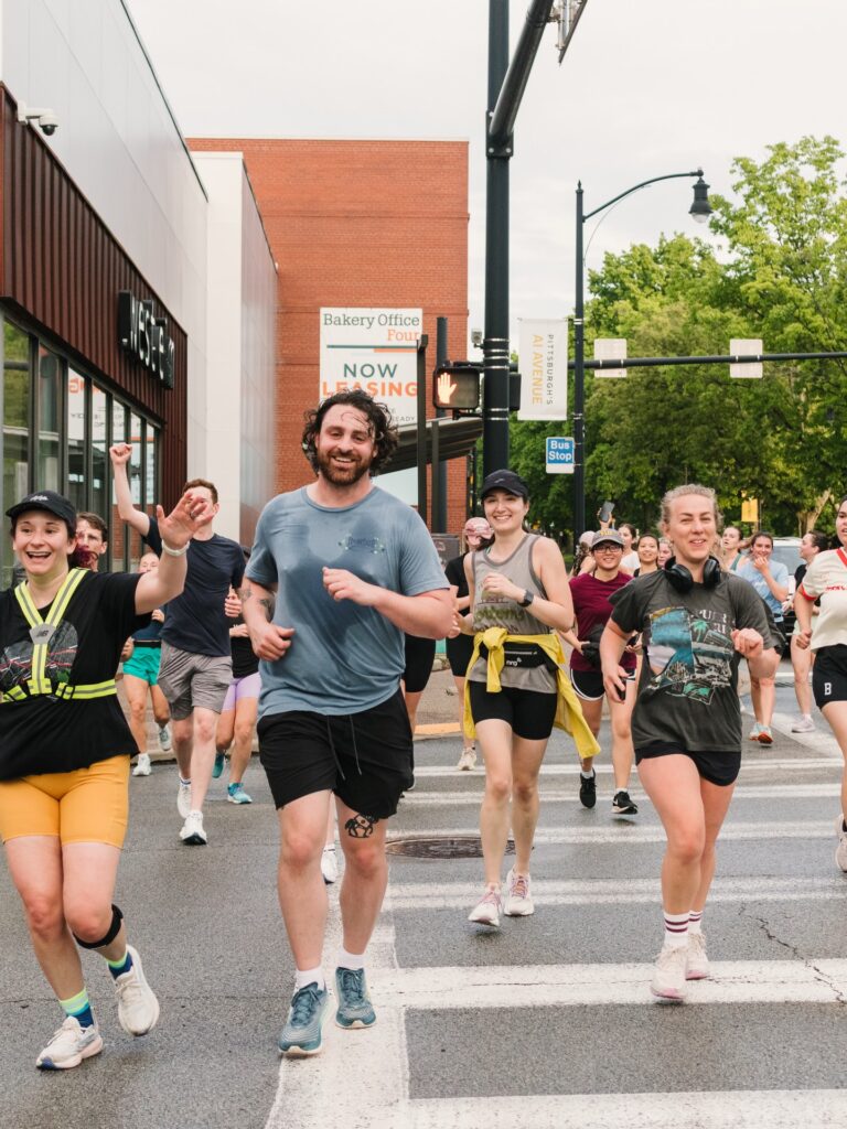 A group of runners run through the streets of Pittsburgh.